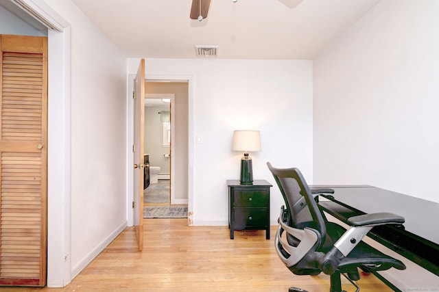 home office featuring ceiling fan, light wood finished floors, visible vents, and baseboards