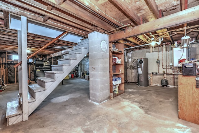 unfinished basement featuring electric water heater and stairway