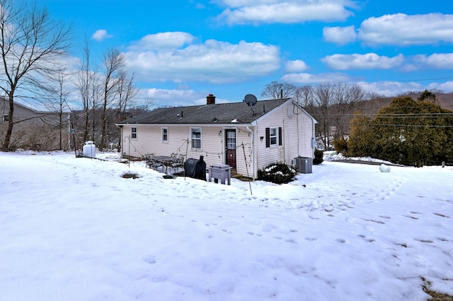 snow covered house featuring central air condition unit