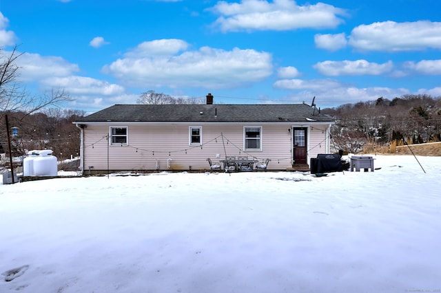 view of snow covered rear of property