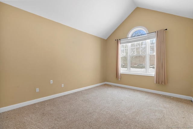 unfurnished room featuring vaulted ceiling, carpet, and baseboards