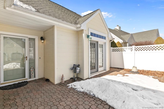 entrance to property with fence and roof with shingles