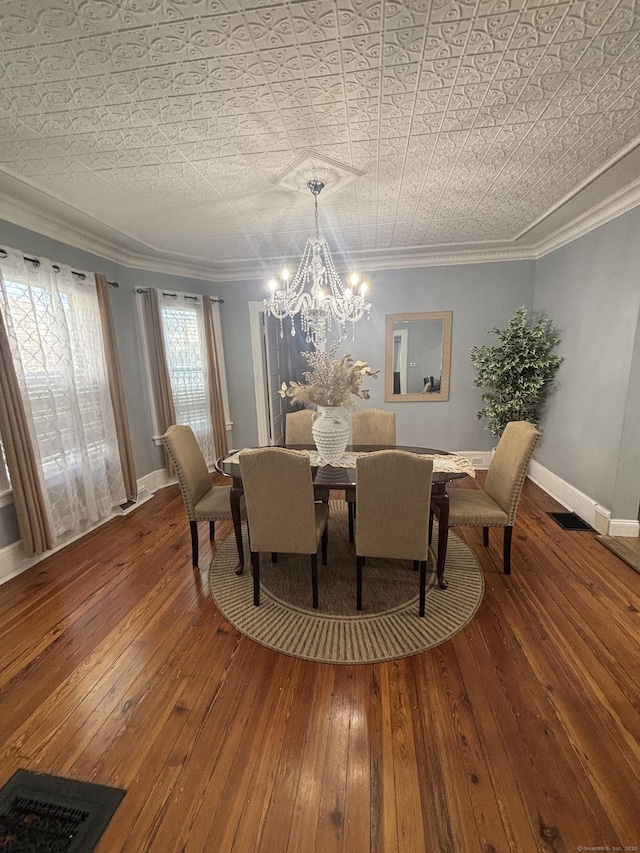 dining space featuring an ornate ceiling, crown molding, and wood finished floors