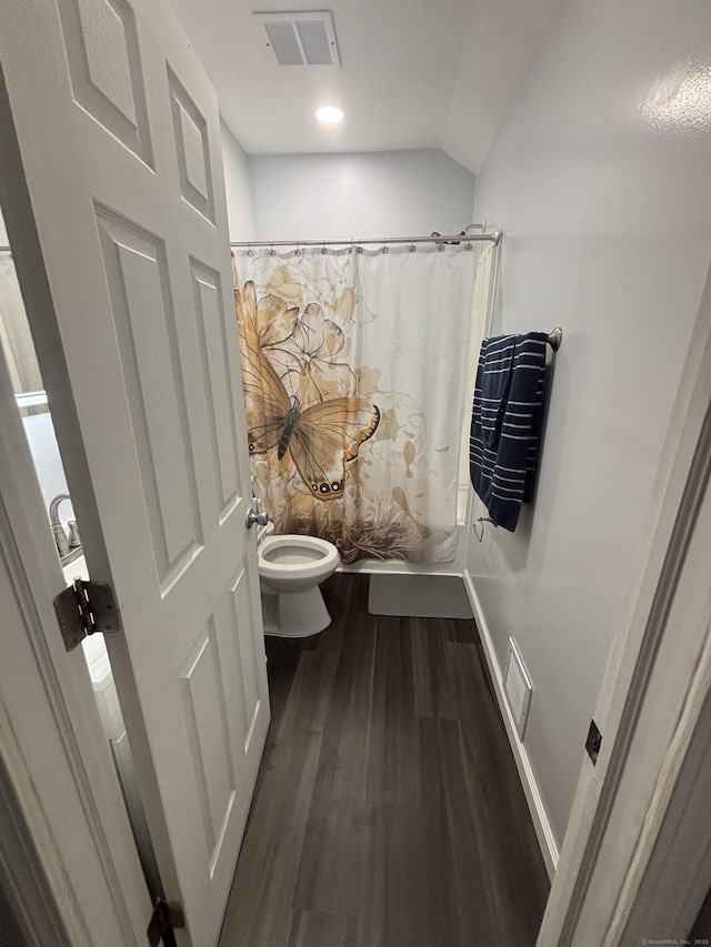 bathroom with toilet, visible vents, wood finished floors, and a shower with shower curtain