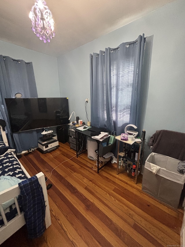 bedroom with dark wood-style floors and a chandelier