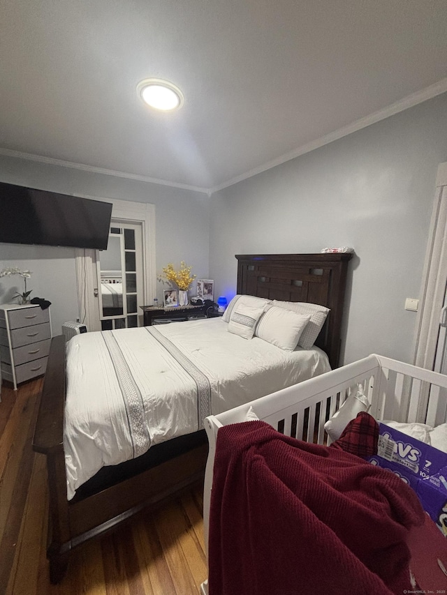 bedroom featuring crown molding and wood finished floors