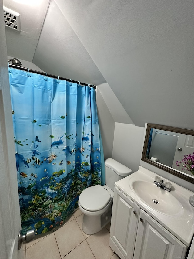 bathroom with visible vents, toilet, vaulted ceiling, vanity, and tile patterned flooring