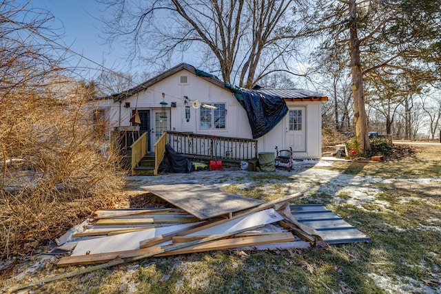 back of property featuring metal roof and a deck