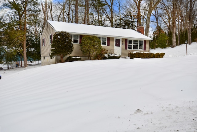 single story home with entry steps and a chimney