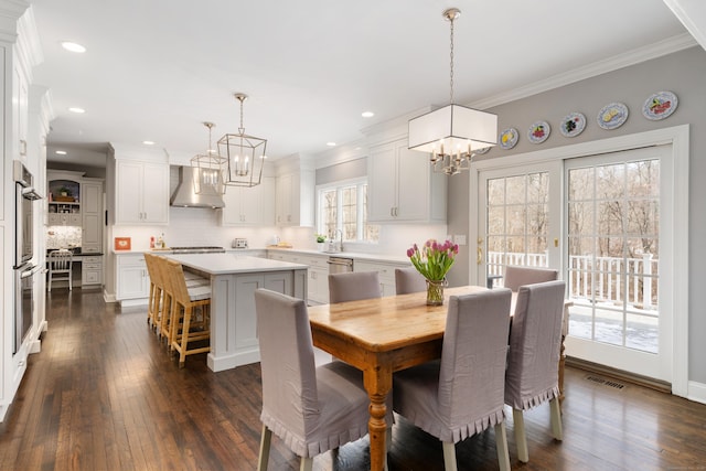 dining space with dark wood finished floors, recessed lighting, visible vents, ornamental molding, and a chandelier