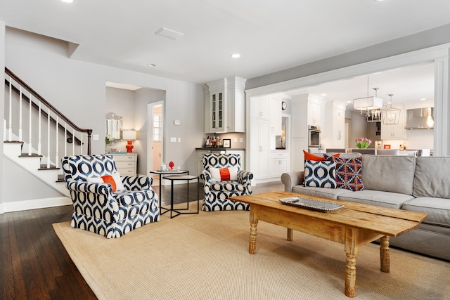 living area featuring dark wood-style flooring, a notable chandelier, recessed lighting, stairway, and baseboards