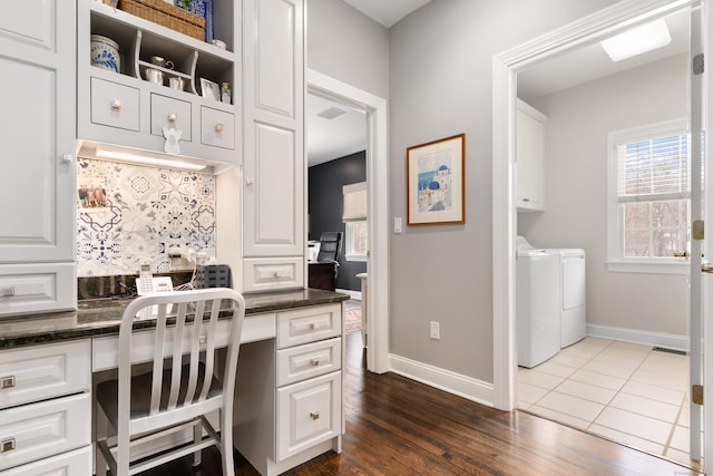 office area featuring independent washer and dryer, baseboards, dark wood-style floors, and built in study area