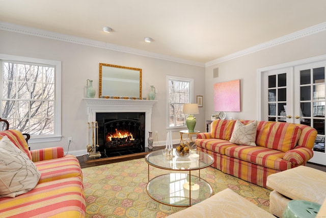 living room featuring crown molding, a warm lit fireplace, plenty of natural light, and french doors