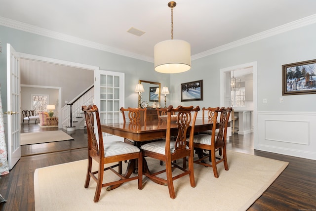 dining area with visible vents, stairway, wainscoting, dark wood finished floors, and crown molding