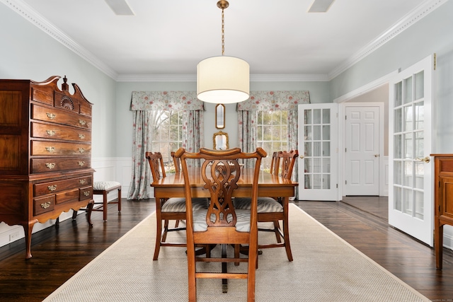 dining space featuring crown molding, french doors, dark wood-type flooring, and wainscoting