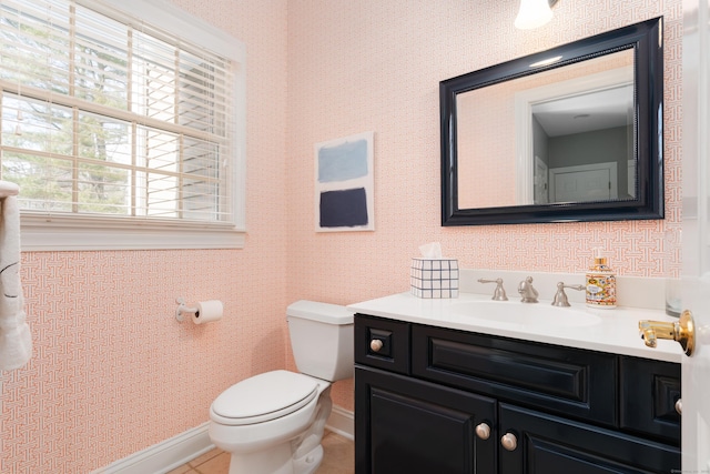 half bathroom with tile patterned flooring, toilet, vanity, baseboards, and wallpapered walls