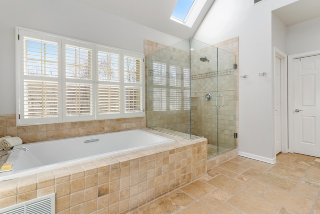 full bath featuring visible vents, lofted ceiling with skylight, a shower stall, and a wealth of natural light