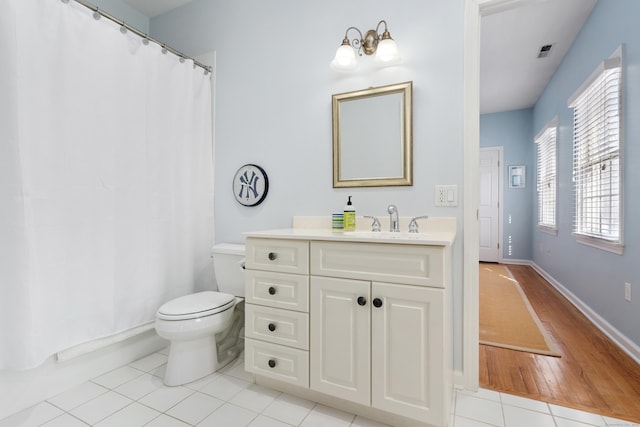 full bathroom featuring visible vents, toilet, vanity, baseboards, and tile patterned floors