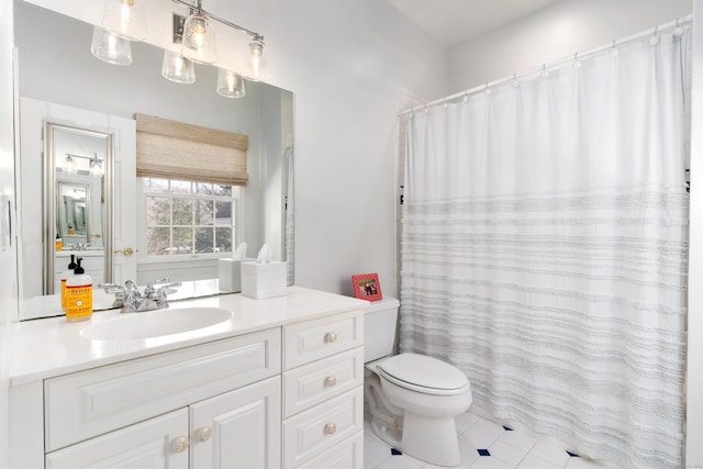 bathroom with toilet, vanity, and tile patterned floors