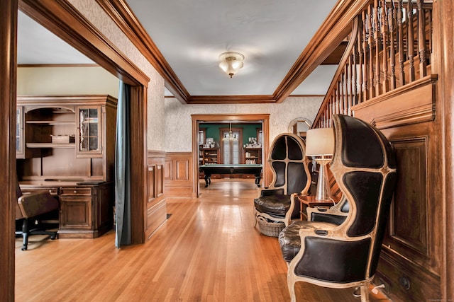 interior space featuring light wood-style flooring, ornamental molding, and wainscoting