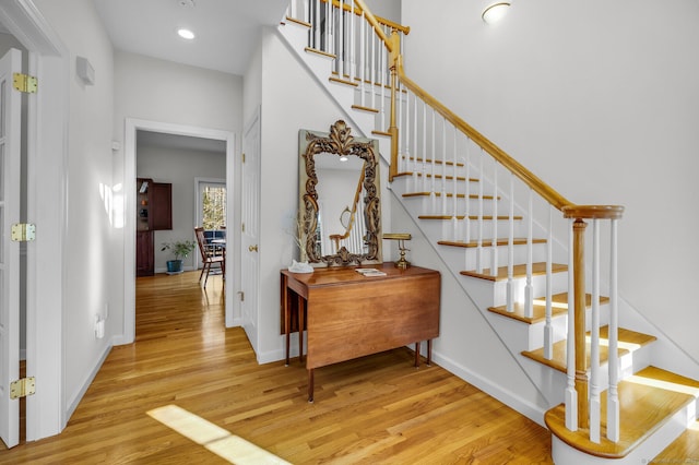 stairway with recessed lighting, baseboards, and wood finished floors