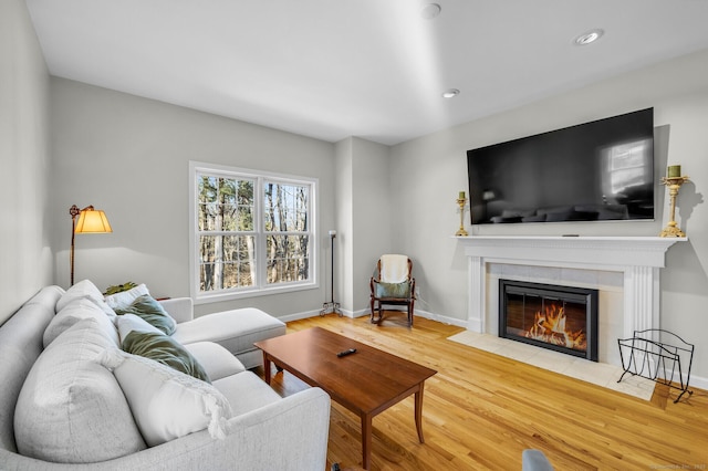 living area featuring recessed lighting, baseboards, wood finished floors, and a tile fireplace