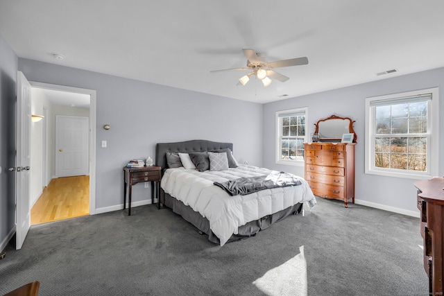 carpeted bedroom with visible vents, baseboards, and ceiling fan