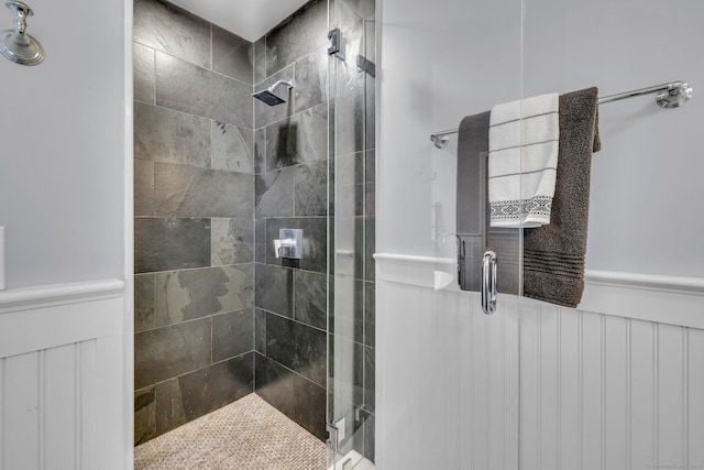 bathroom with wainscoting and a shower stall