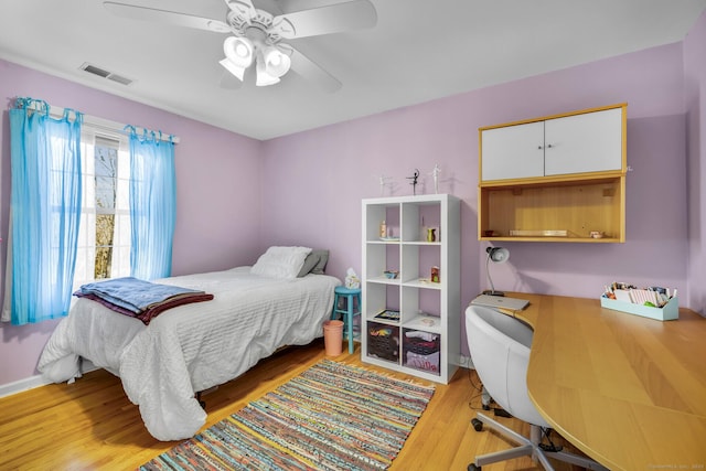 bedroom featuring a ceiling fan, visible vents, and light wood finished floors