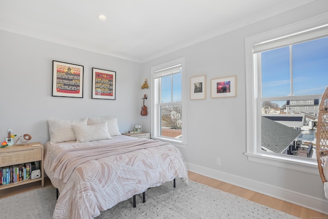 bedroom featuring crown molding, baseboards, and wood finished floors