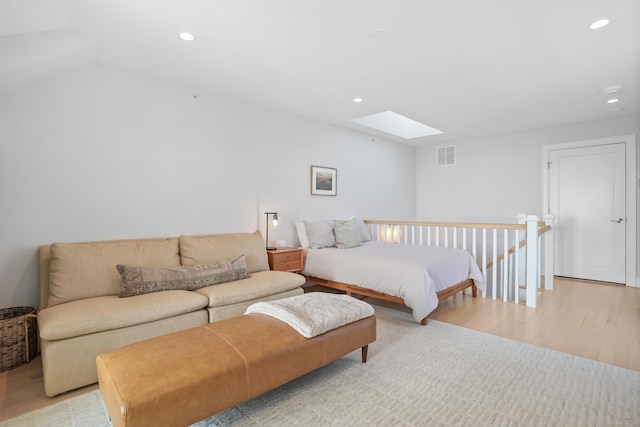 bedroom featuring lofted ceiling with skylight, recessed lighting, visible vents, and light wood-style floors