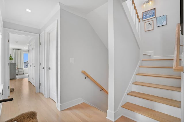 staircase with crown molding, recessed lighting, wood finished floors, and baseboards