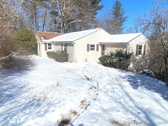 view of snow covered exterior with a chimney