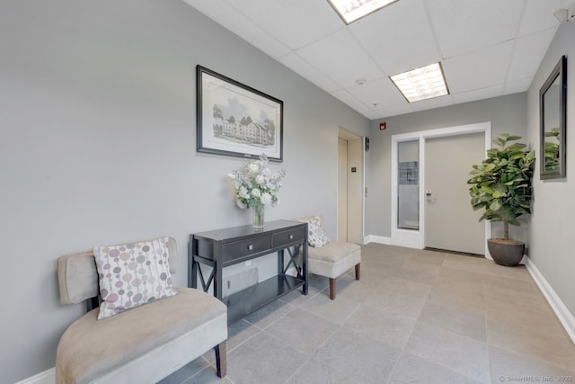 interior space with a drop ceiling and baseboards