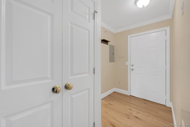 foyer entrance with baseboards, electric panel, light wood-style flooring, and crown molding