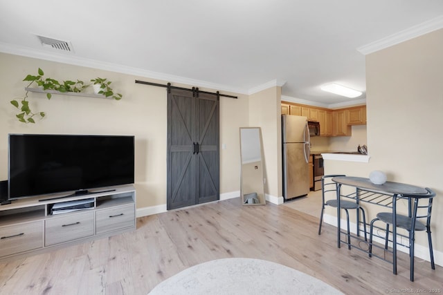 living room with a barn door, baseboards, visible vents, light wood-style flooring, and crown molding