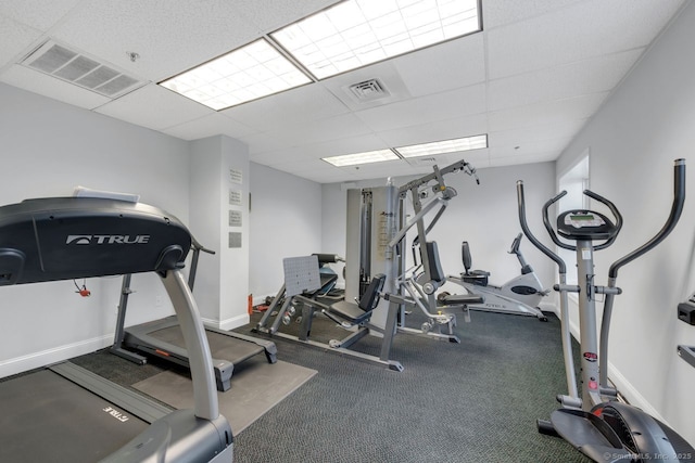 exercise room featuring baseboards, visible vents, and a drop ceiling