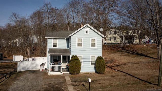 traditional-style house featuring a shingled roof, fence, a porch, and central AC