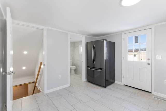 kitchen with baseboards, visible vents, and freestanding refrigerator