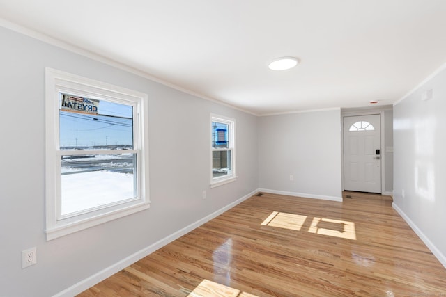 entryway with light wood finished floors, baseboards, and crown molding