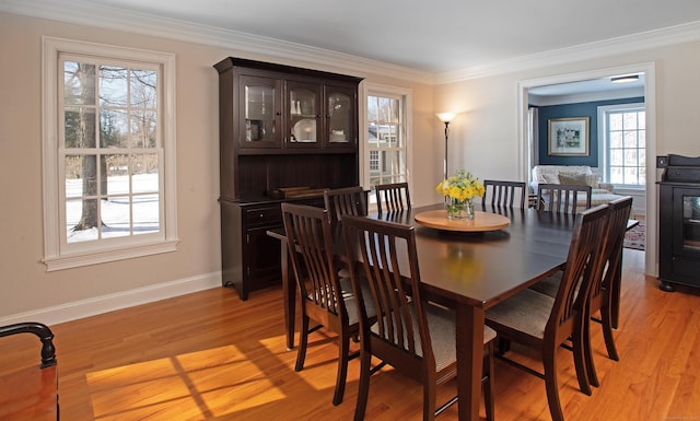 dining room with baseboards, light wood-style floors, and ornamental molding