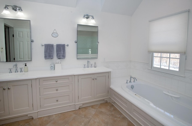 full bathroom featuring double vanity, a bath, and a sink