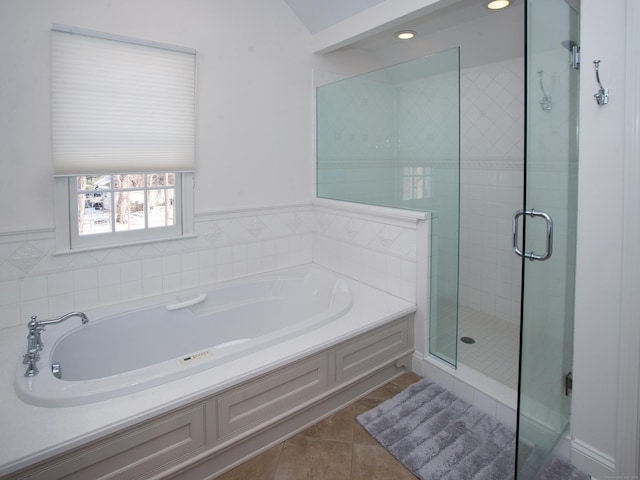 bathroom with tile patterned flooring, a garden tub, and a stall shower