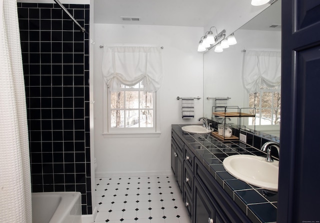 bathroom with visible vents, plenty of natural light, and a sink