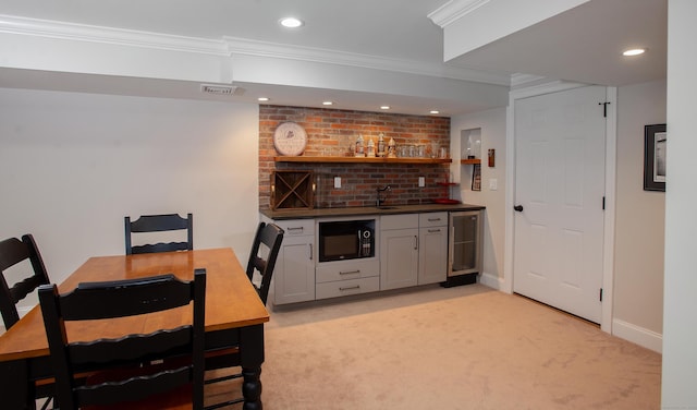 interior space featuring ornamental molding, recessed lighting, black microwave, indoor wet bar, and light colored carpet