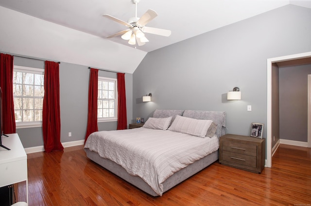 bedroom with lofted ceiling, wood finished floors, baseboards, and ceiling fan