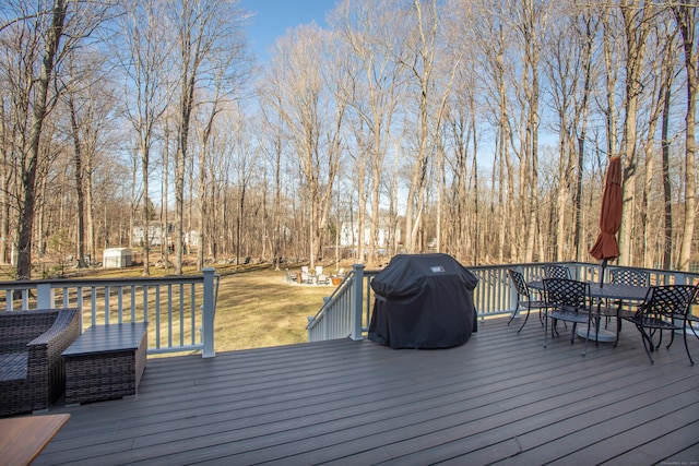 wooden deck featuring grilling area, a yard, and outdoor dining space