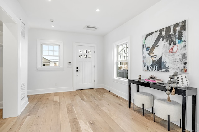 foyer with visible vents, baseboards, hardwood / wood-style floors, and recessed lighting