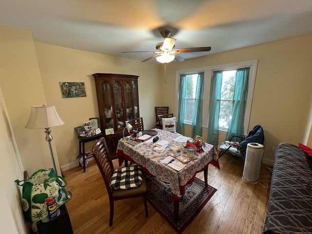 dining area featuring ceiling fan, baseboards, and wood finished floors