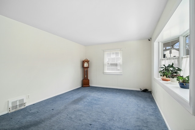 carpeted empty room featuring baseboards, visible vents, and a wealth of natural light